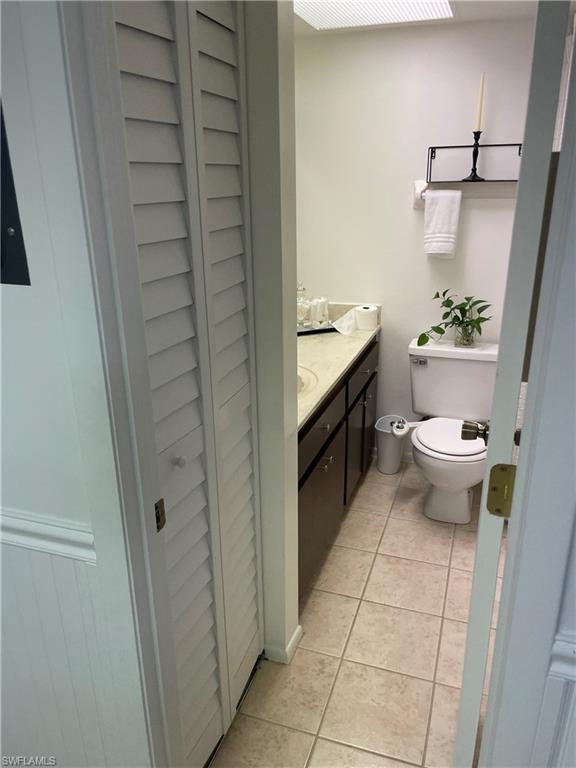 Bathroom with vanity, a closet, and light tile patterned floors