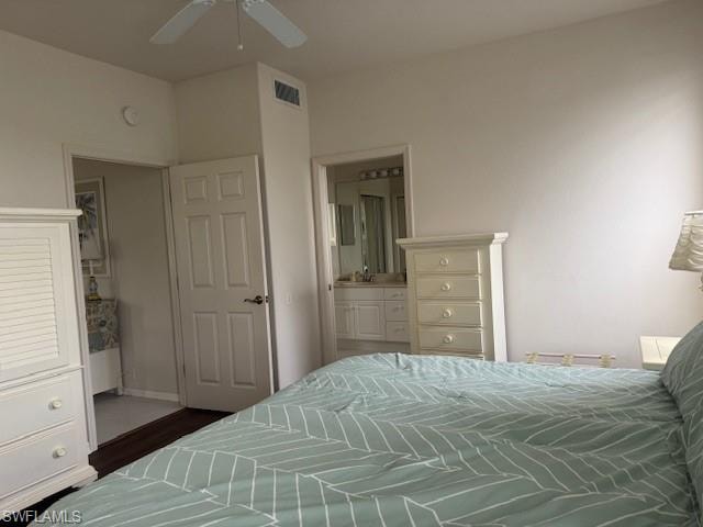 Bedroom featuring ensuite bathroom, a ceiling fan, and wood finished floors