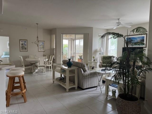 Living room with a ceiling fan and light tile patterned floors