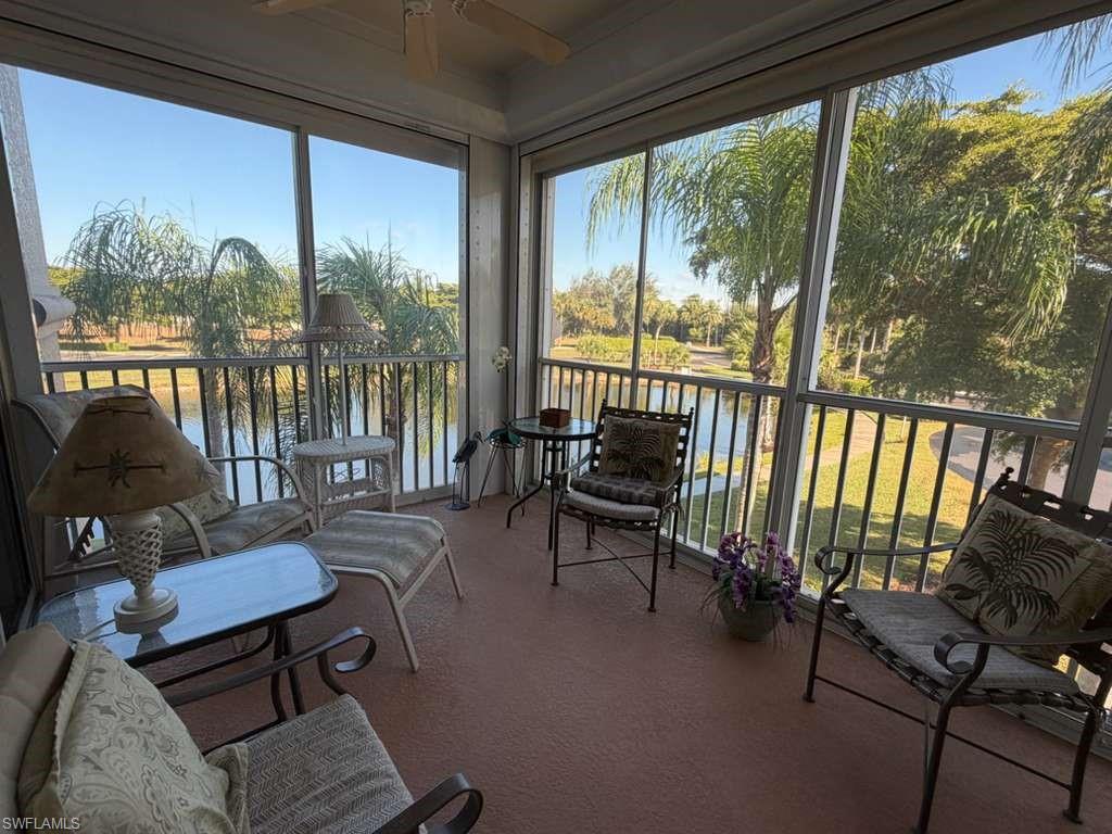 Sunroom featuring a ceiling fan, a balcony, and healthy amount of natural light