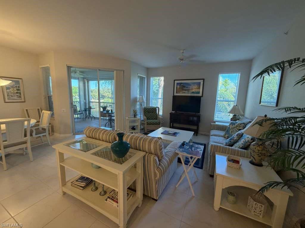 Living room featuring a ceiling fan, light tile patterned floors, and plenty of natural light