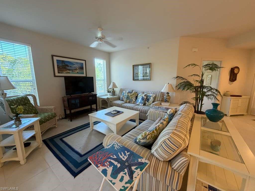 Living area with ceiling fan and light tile patterned flooring