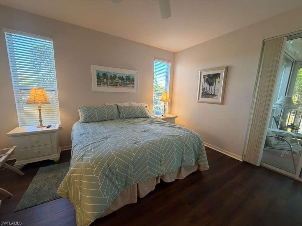 Bedroom featuring access to exterior, dark wood-style floors, and ceiling fan
