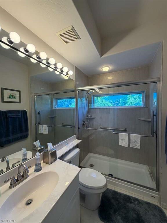 Full bathroom with vanity and a stall shower