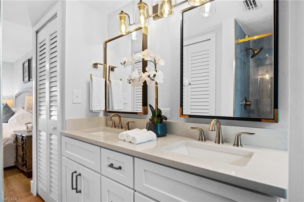 Ensuite bathroom featuring a closet, double vanity, and a shower