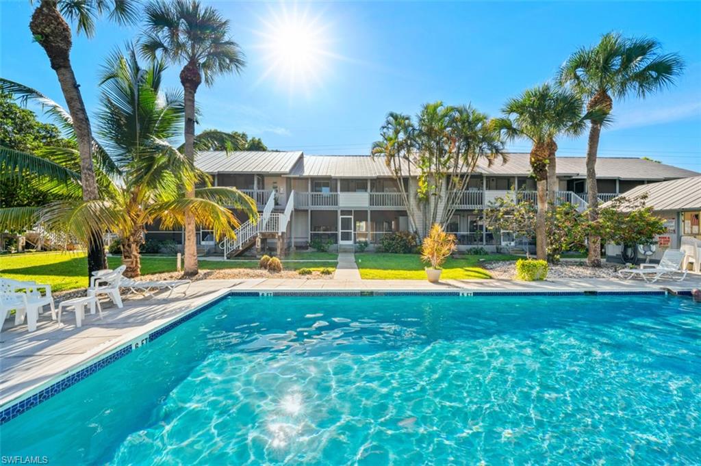 Community pool with a patio area and a yard