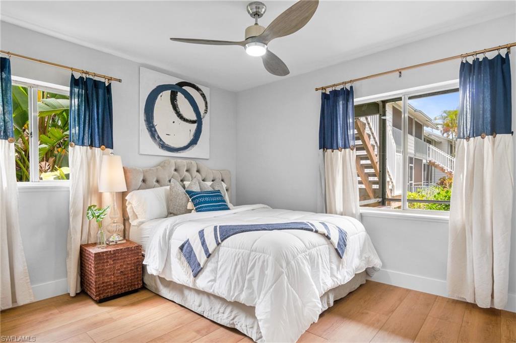 Bedroom featuring hardwood / wood-style flooring, a ceiling fan, and multiple windows