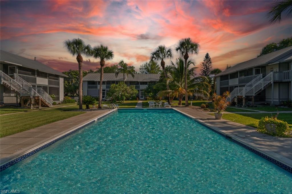 Pool at dusk with a lawn and an outdoor pool