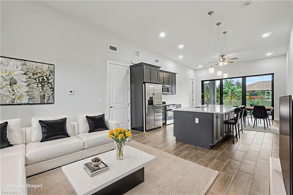 Living area with ceiling fan, wood finish floors, and recessed lighting
