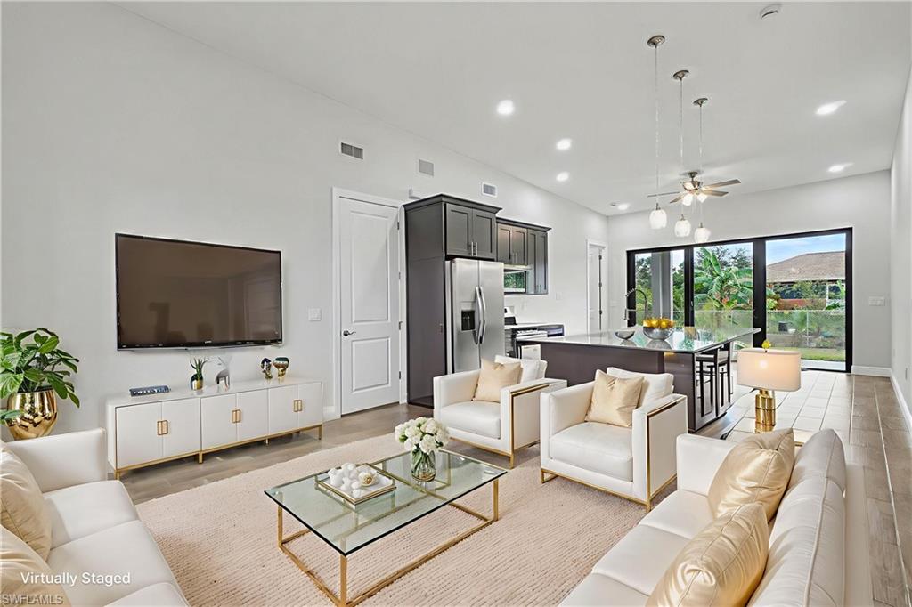 Living room featuring a ceiling fan, wood tiled floors, and recessed lighting