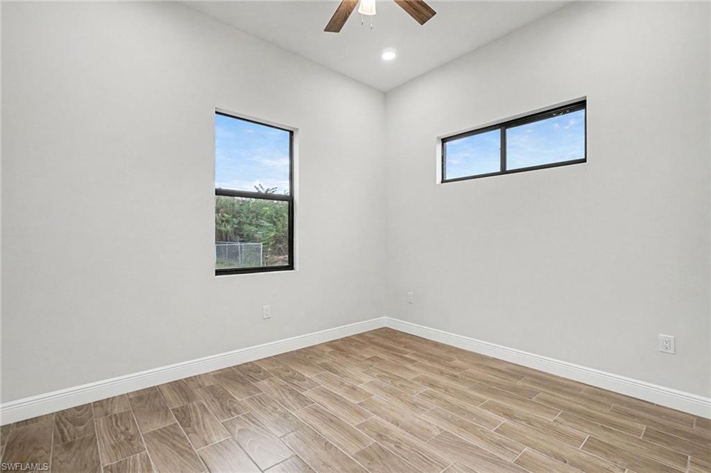 Spare room with wood finish floors, a ceiling fan, and recessed lighting