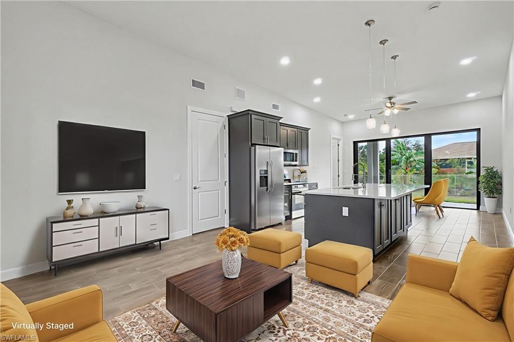 Living area with wood finish floors, ceiling fan, and recessed lighting