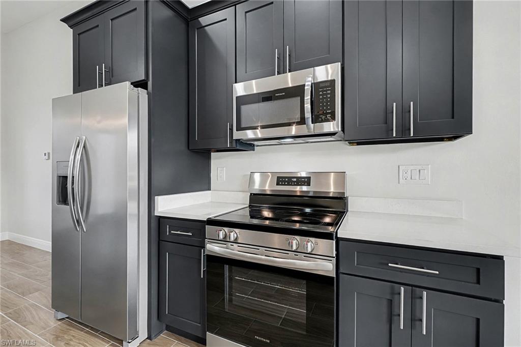Kitchen featuring stainless steel appliances and light stone countertops