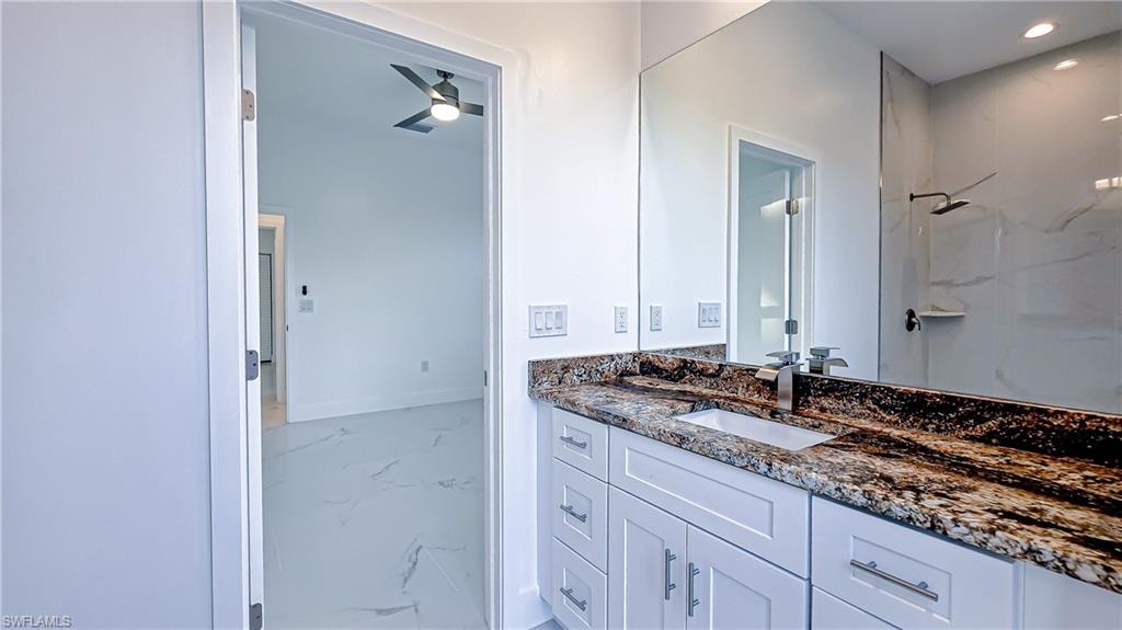 Bathroom featuring vanity, a marble finish shower, ceiling fan, and recessed lighting