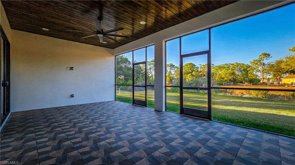 Unfurnished sunroom featuring ceiling fan