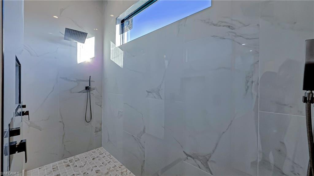 Bathroom featuring a marble finish shower