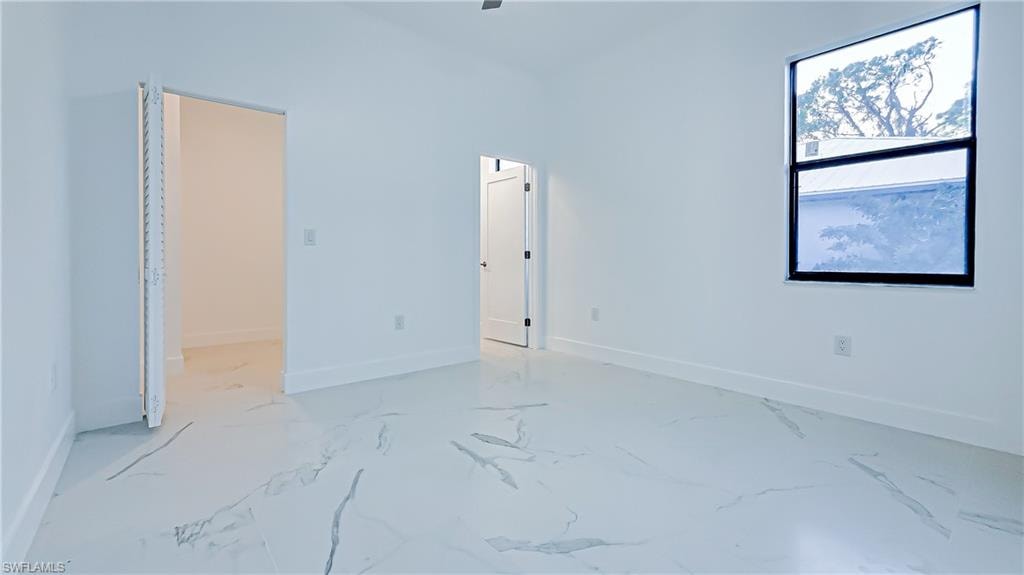 Unfurnished bedroom with a walk in closet and a ceiling fan