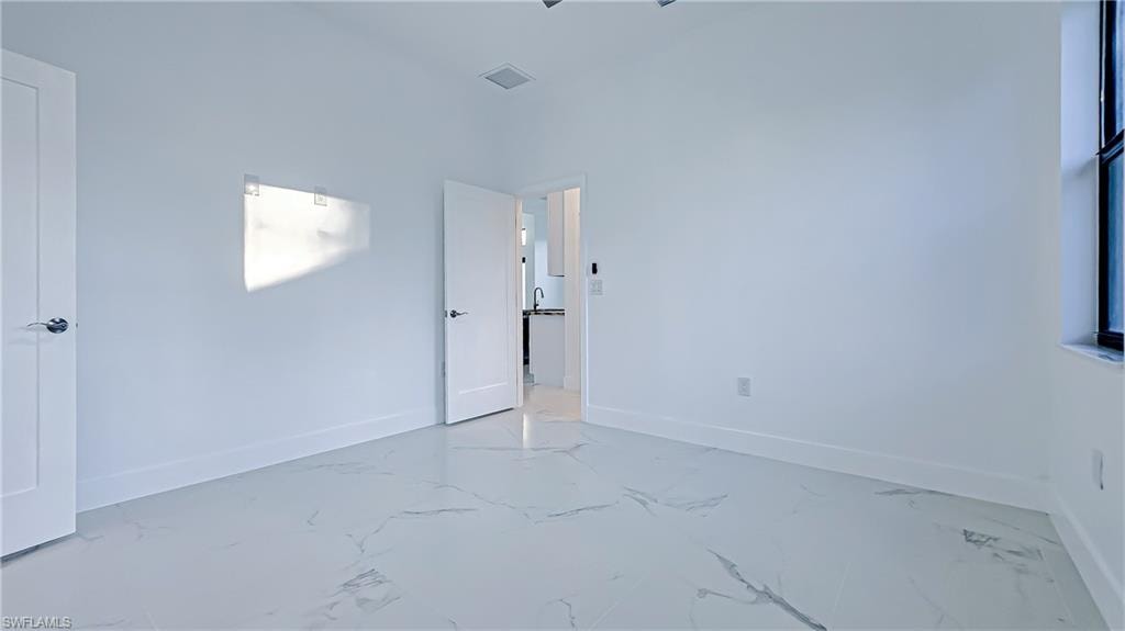 Unfurnished bedroom with baseboards and marble finish flooring