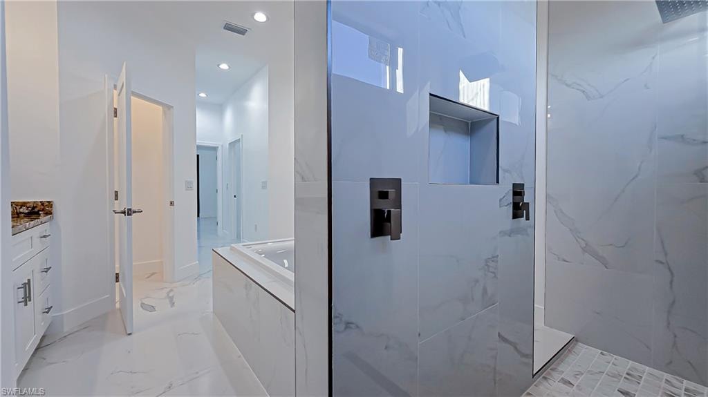 Full bathroom featuring vanity, a garden tub, a marble finish shower, recessed lighting, and light marble finish floors