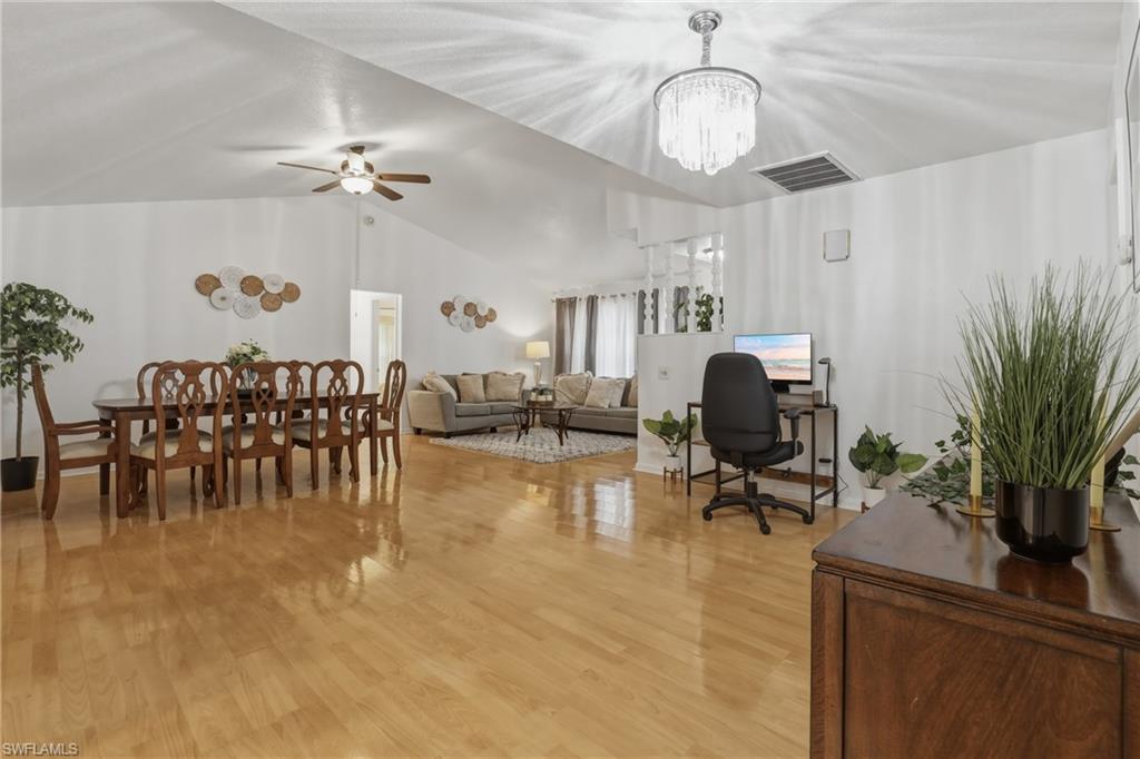 Office with vaulted ceiling, a ceiling fan, and suspended lighting