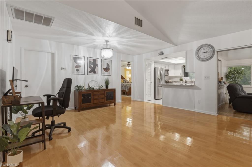 Office with light wood-type flooring, vaulted ceiling, and ceiling fan
