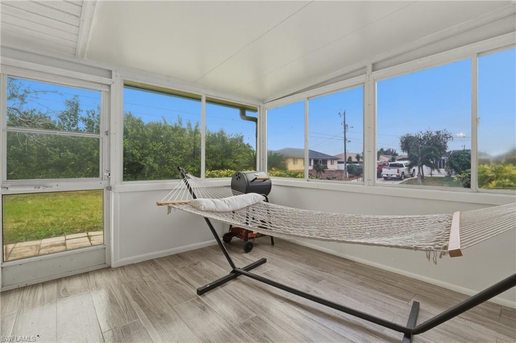 Sunroom / solarium featuring wood finished floors and baseboards