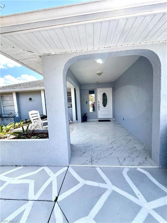 Doorway to property with stucco siding and a patio