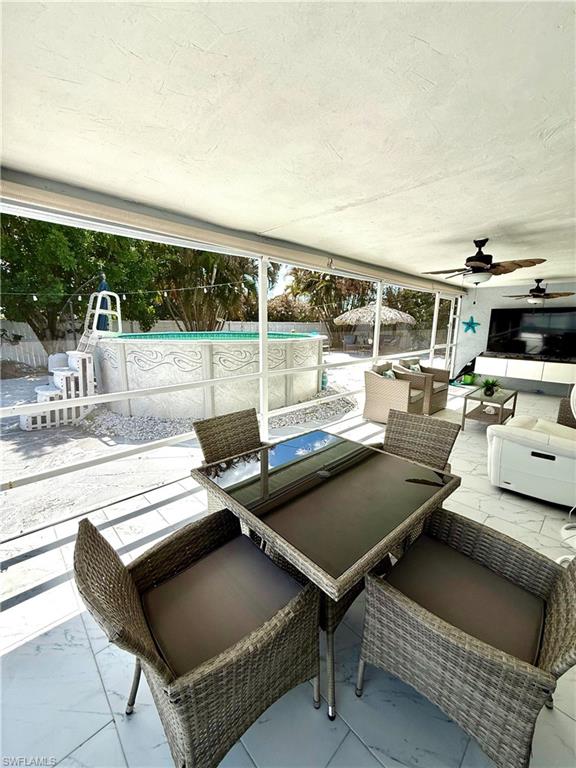 Fenced backyard with outdoor seating, a ceiling fan, a patio area, and an outdoor pool
