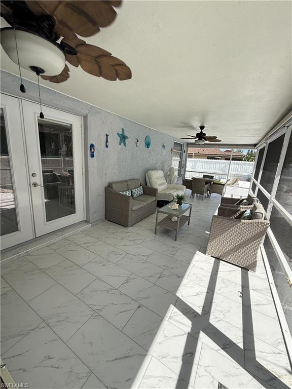 View of patio / terrace featuring a ceiling fan, a sunroom, and outdoor lounge area