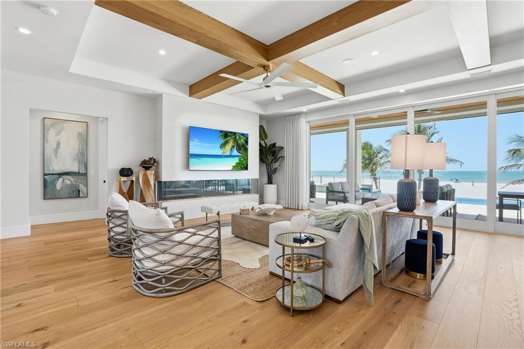 Living room with coffered ceiling, light wood-type flooring, ceiling fan, and recessed lighting - Virtually Edited Image