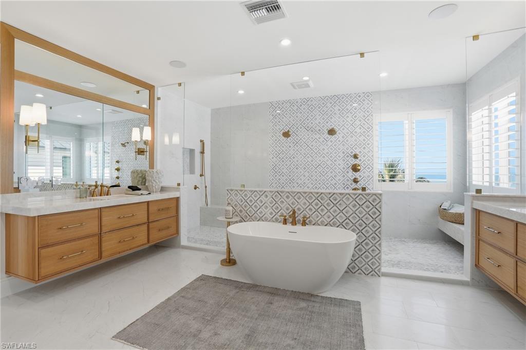 Bathroom featuring vanity, walk in shower, a freestanding tub, and tile walls - Virtually Edited Image