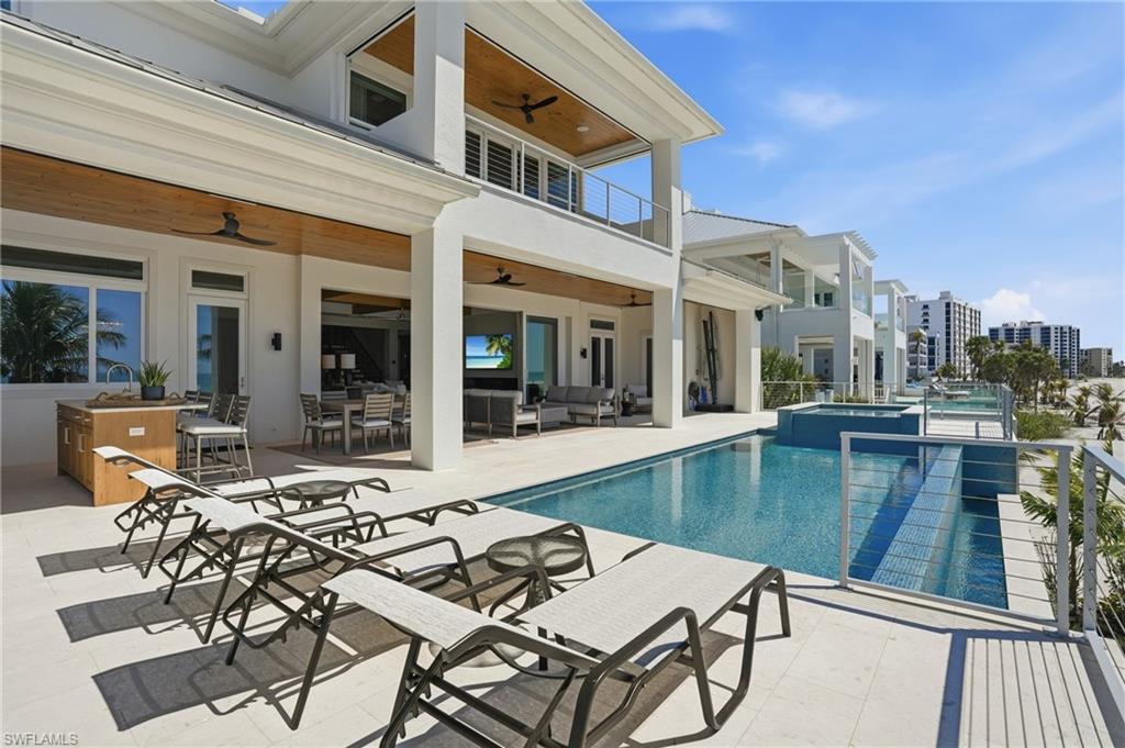 Relaxing pool / spa featuring an outdoor living / dining area, a patio area, and a balcony - Virtually Edited Image
