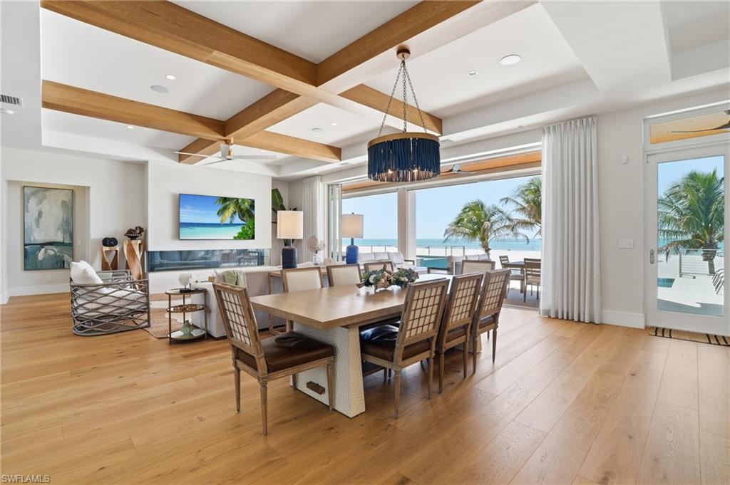 Dining area featuring light wood-style floors, coffered ceiling, ceiling fan, and recessed lighting - Virtually Edited Image