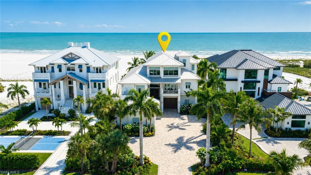 Luxurious beachfront home showcasing three architecturally distinct residences set across manicured grounds  - Virtually Edited Image