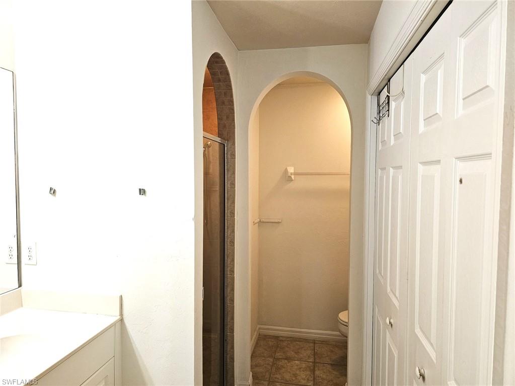 Full bathroom featuring vanity, a shower stall, and tile patterned flooring