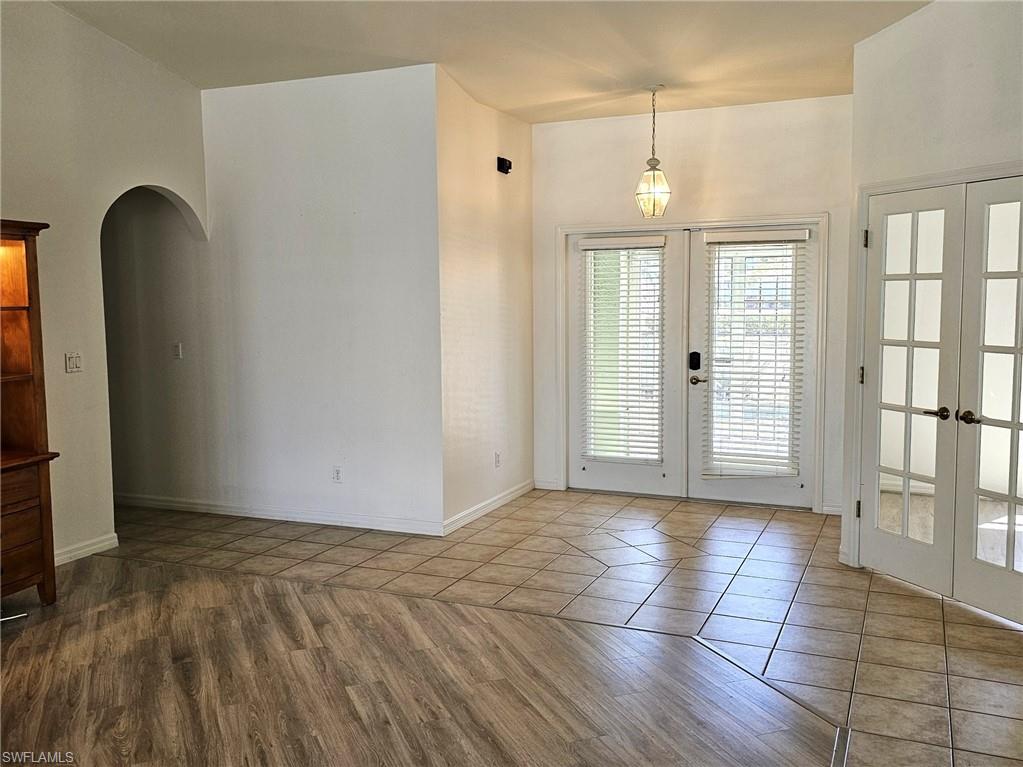 Doorway featuring french doors, arched walkways, and wood finished floors