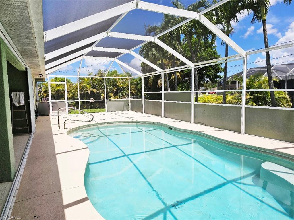 Swimming pool featuring a patio, glass enclosure, and a sunroom