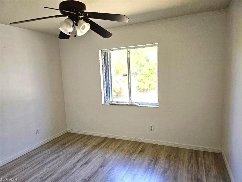 Spare room with wood finished floors and ceiling fan