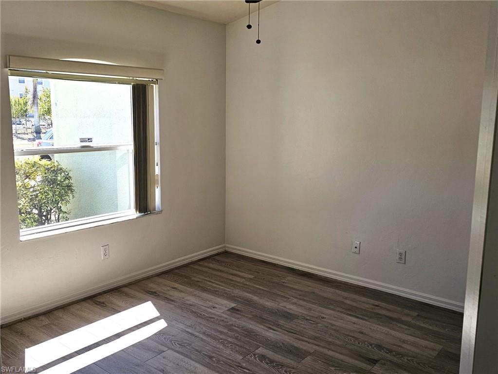 Spare room with dark wood-style floors and a ceiling fan