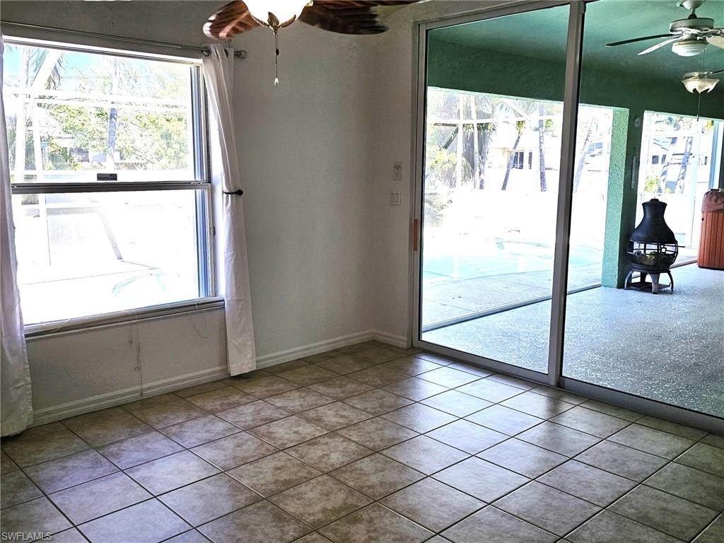 Doorway to outside with ceiling fan, plenty of natural light, and tile patterned floors