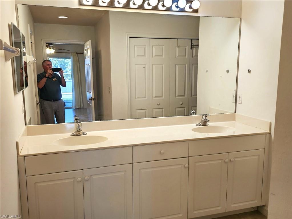 Full bathroom with double vanity and a closet