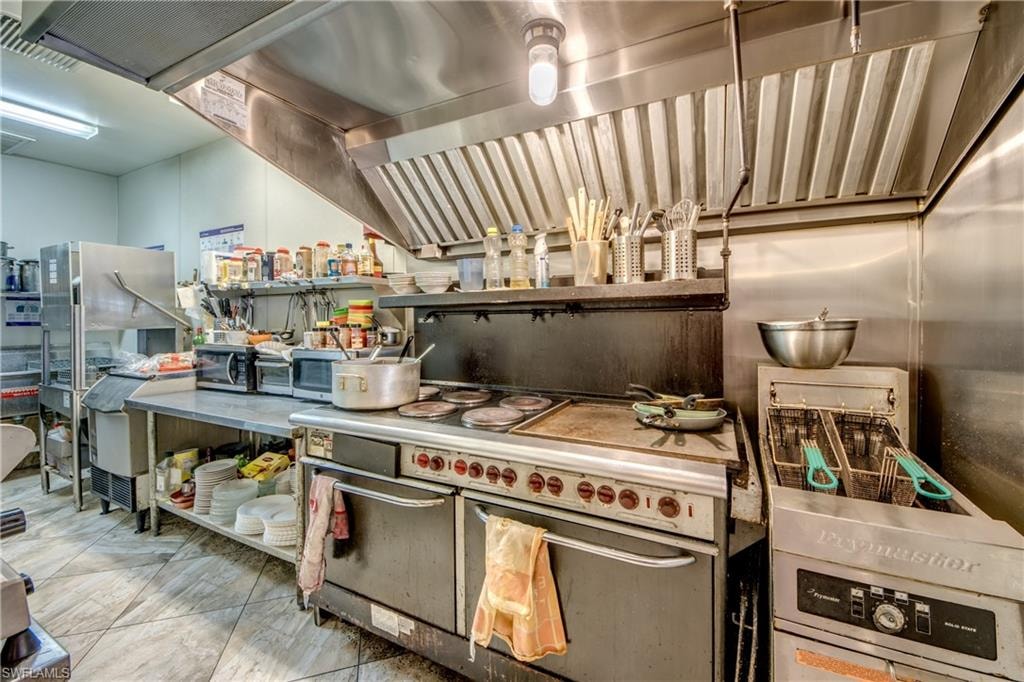 Kitchen with exhaust hood and range with two ovens