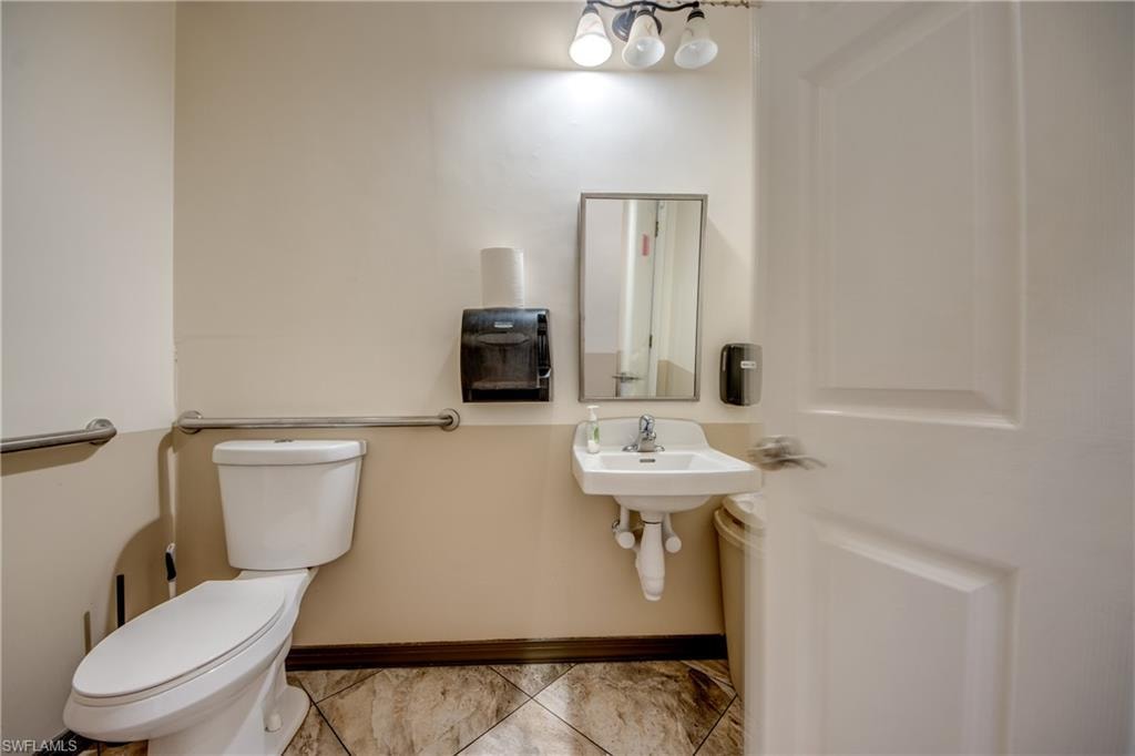 Bathroom featuring toilet and light marble finish floors