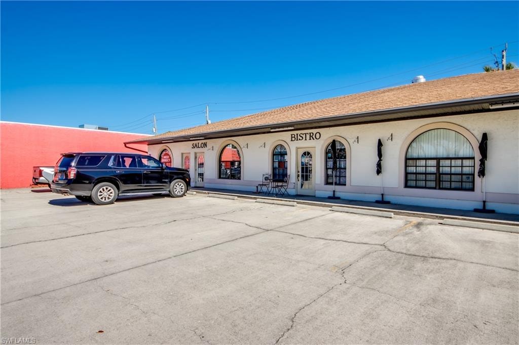 View of building exterior with uncovered parking