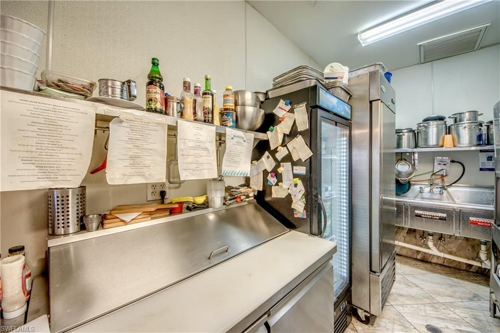 Kitchen featuring light countertops and freestanding refrigerator