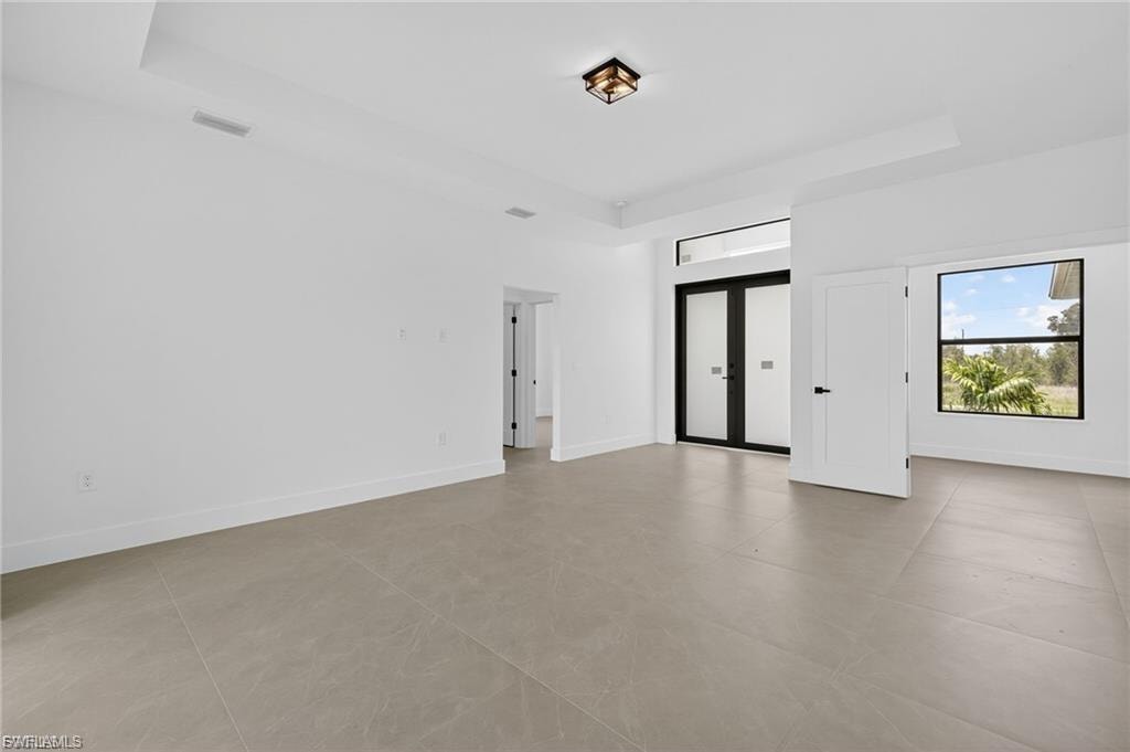 Empty room with a raised ceiling and french doors