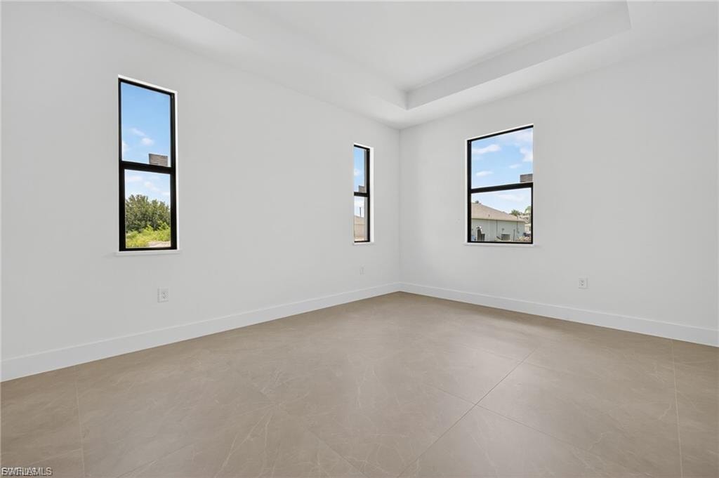 Empty room featuring plenty of natural light and a raised ceiling