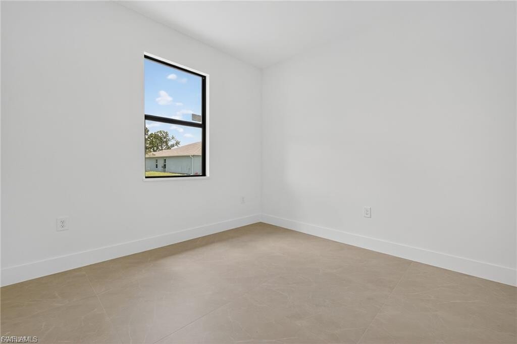 Unfurnished room featuring baseboards and concrete flooring