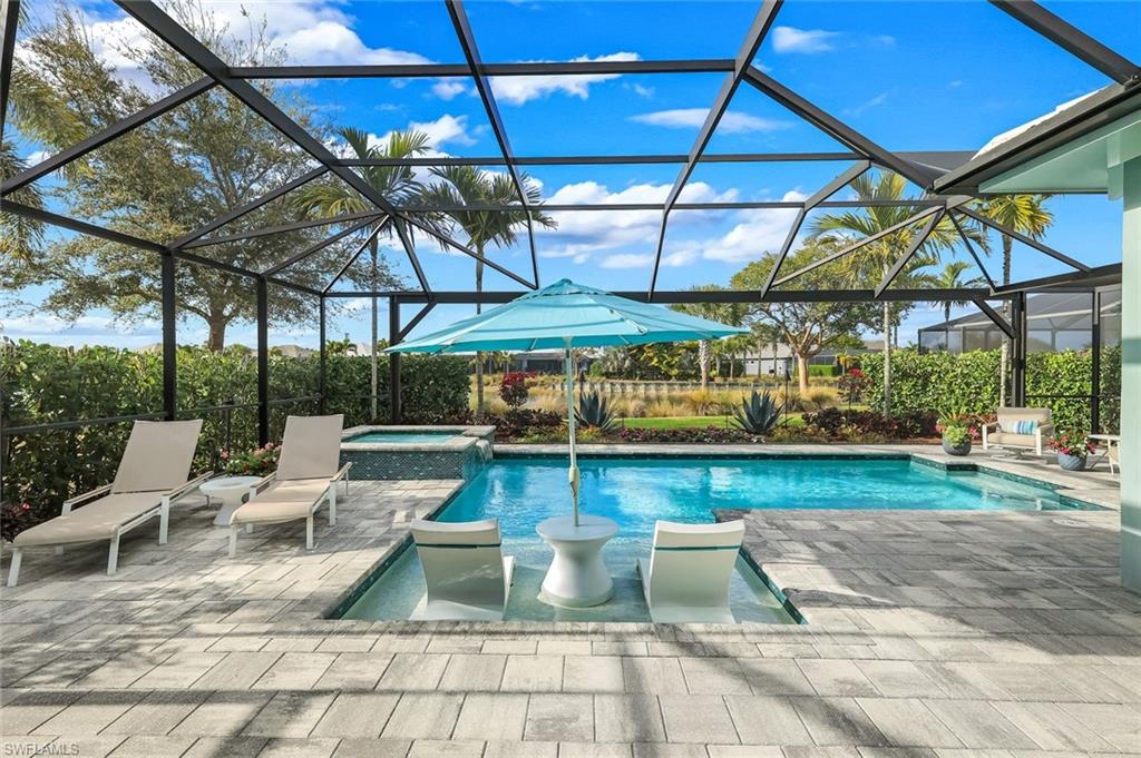 Relaxing pool / spa featuring a sunroom, a lanai, and a patio