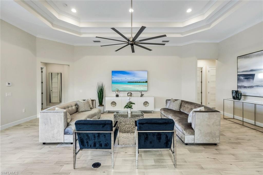Living area featuring ceiling fan, wood tiled floors, and ornamental molding
